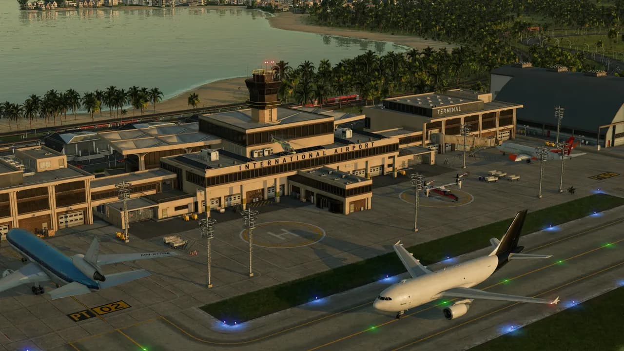 Aeroporto junto ao mar com aviões na pista e uma estação ao lado